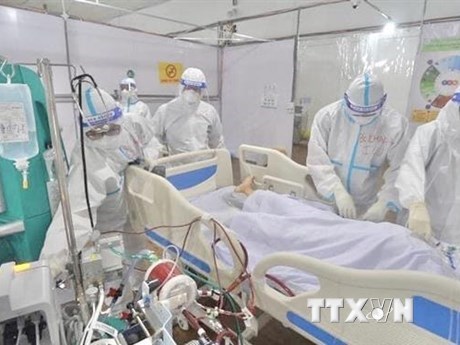 Bác sỹ chăm sóc bệnh nhân COVID-19 tại bệnh viện dã chiến điều trị bệnh nhân COVID-19 đa tầng ở quận Tân Bình. (Ảnh: TTXVN phát)
