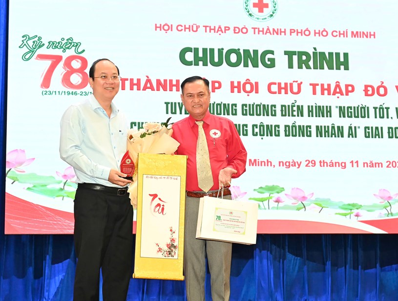 Chủ tịch Hội Chữ thập đỏ TPHCM Trần Trường Sơn tặng hoa cảm ơn Ph&oacute; B&iacute; thư Thường trực Th&agrave;nh ủy TPHCM Nguyễn Hồ Hải, Chủ tịch danh dự Hội Chữ Thập đỏ TPHCM. Ảnh: VIỆT DŨNG