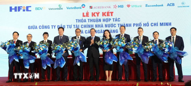 L&atilde;nh đạo Ủy ban Nh&acirc;n d&acirc;n Th&agrave;nh phố Hồ Ch&iacute; Minh c&ugrave;ng c&aacute;c ng&acirc;n h&agrave;ng tham gia lễ k&yacute; kết thỏa thuận hợp t&aacute;c. (Ảnh: Hứa Chung/TTXVN)