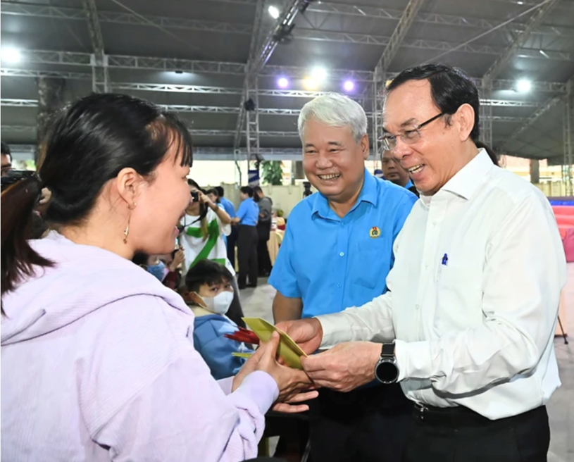 Bí thư Thành ủy TPHCM Nguyễn Văn Nên thăm hỏi, tặng quà công nhân lao động sáng 26-1. Ảnh: VIỆT DŨNG