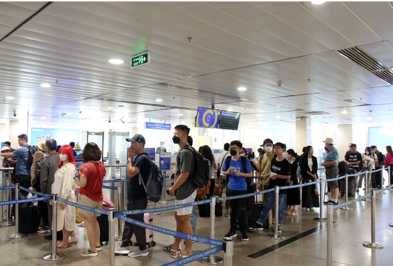 Hành khách xếp hàng vào khu vực soi chiếu kiểm tra an ninh tại Sân bay Tân Sơn Nhất. (Ảnh: Tiến Lực/TTXVN)