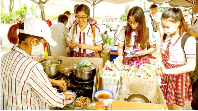 Học sinh chuộng thức ăn nhanh được b&agrave;y b&aacute;n trước cổng Trường THPT T&acirc;n Phong, quận 7, TPHCM. Ảnh: HO&Agrave;NG H&Ugrave;NG