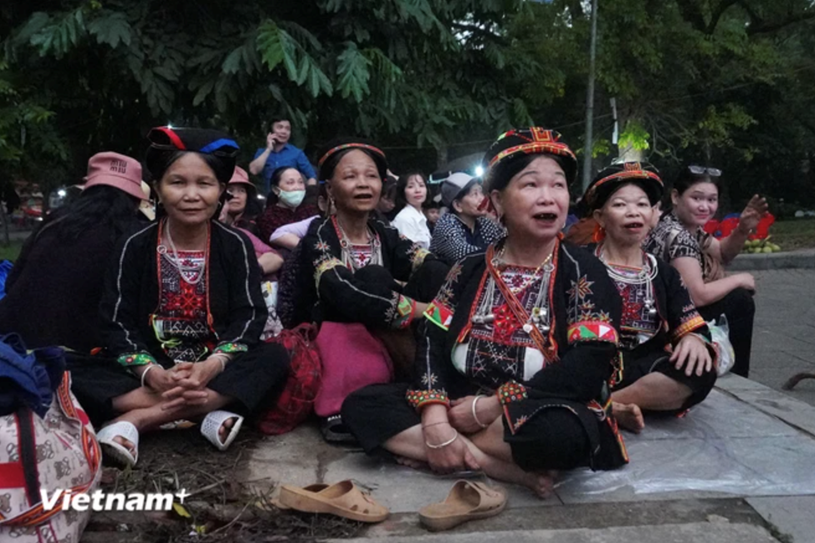 Bà Nguyễn Thị Tuyên (ngoài cùng bên trái) cùng đoàn hành hương 8 người dân tộc Dao (Tuyên Quang) ngồi chờ đến giờ hành hương. (Ảnh: Việt Anh/Vietnam+)