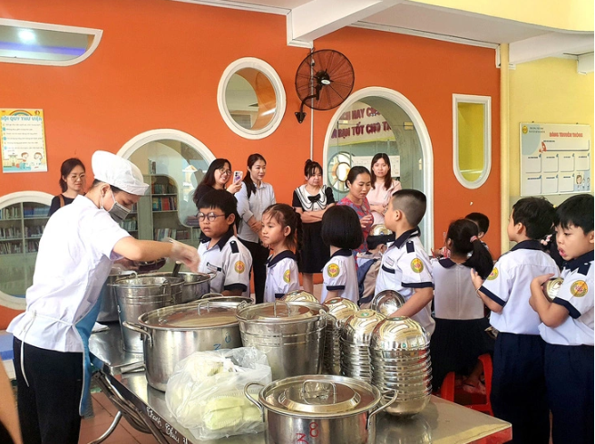 Phụ huynh Trường tiểu học Nguyễn Bỉnh Khiêm (Q.1, TP.HCM) giám sát suất ăn học đường và cùng ăn trưa với con tại trường - Ảnh: TRÂN TRẦN
