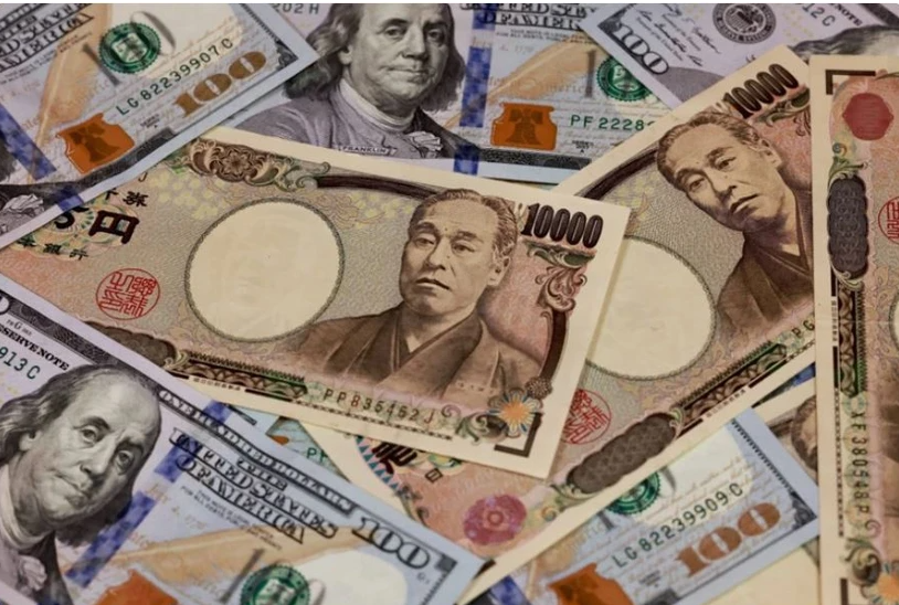 Đồng tiền mệnh giá 10.000 yen và 100 USD. (Ảnh minh họa: AFP/TTXVN)