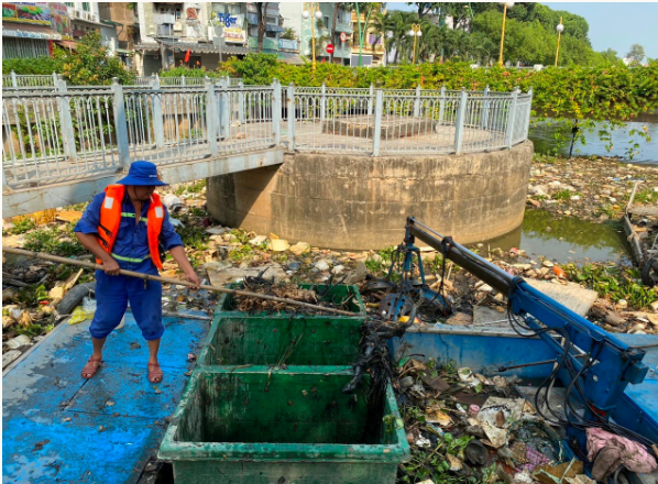 Công nhân vệ sinh môi trường vớt rác và nạo vét bùn thải trên kênh Nhiêu Lộc - Thị Nghè. Ảnh: Hồng Phúc.