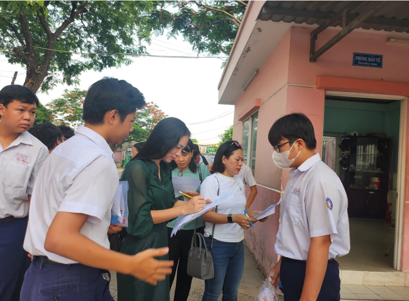Giáo viên Trường THCS Nguyễn Hiền, quận 12 có mặt tại điểm thi từ sớm để điểm danh học trò đến dự thi. Ảnh: NGUYỄN QUYÊN