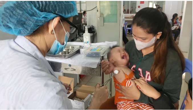 Nhân viên y tế tiêm vaccine cho trẻ