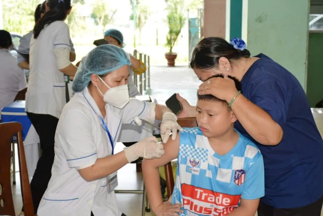 Nhân viên y tế tiêm vaccine cho trẻ