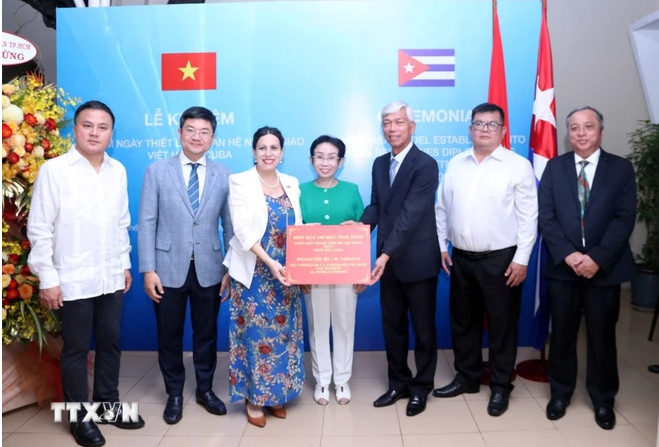 Ông Võ Văn Hoan, Phó Chủ tịch UBND Thành phố Hồ Chí Minh trao tượng trưng cho bà Ariadne Feo Labrada, Tổng lãnh sự Cuba tại Thành phố Hồ Chí Minh món quà 100 máy tính bảng mà Thành phố Hồ Chí Minh tặng nhân dân Cuba. (Ảnh: Xuân Khu/TTXVN)