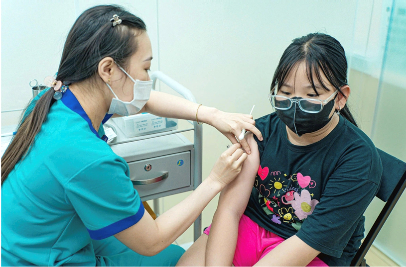 Trẻ em tiêm phòng vắc xin tổng hợp (sởi, quai bị, rubella) tại Trung tâm tiêm chủng FPT Long Châu, quận 1, TP.HCM chiều 8-12 - Ảnh: THANH HIỆP