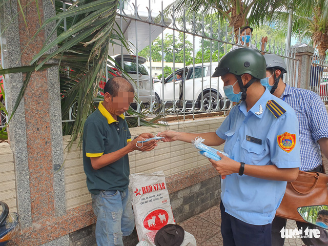 Lực lượng chức năng phường Bến Ngh&eacute;, quận 1 nhắc nhở, ph&aacute;t khẩu trang cho người kh&ocirc;ng đeo khẩu trang. Ảnh: MINH H&Ograve;A