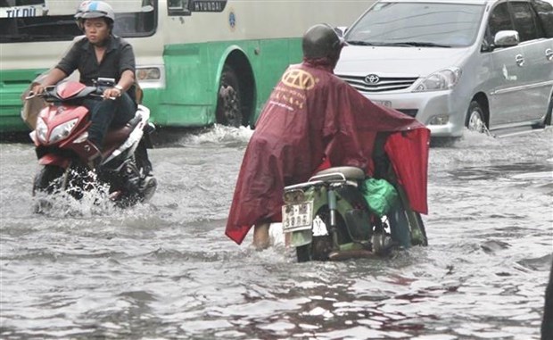 Nước ngập s&acirc;u khiến nhiều phương tiện chết m&aacute;y, người d&acirc;n phải dẫn bộ. Ảnh: Hồng Giang/TTXVN