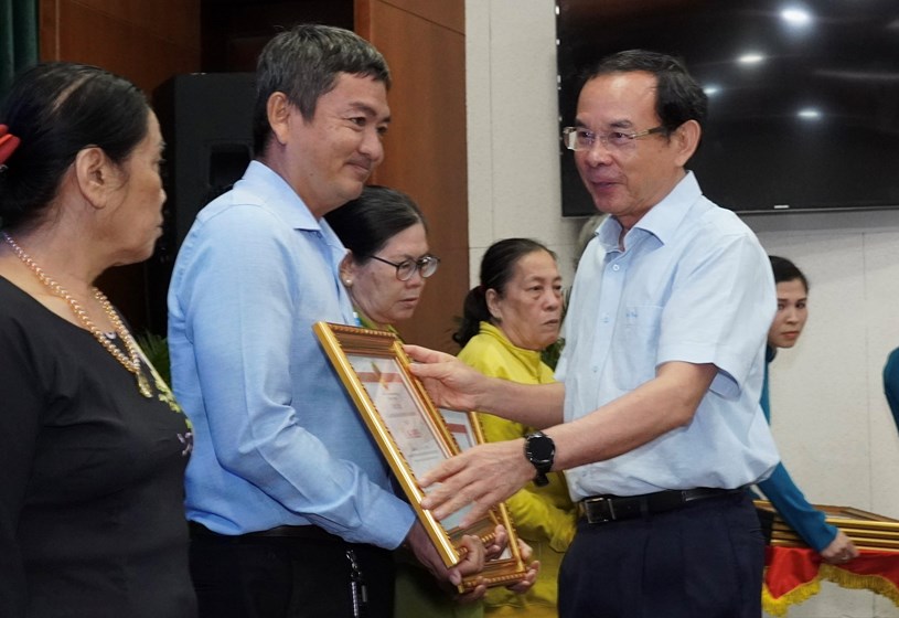 B&iacute; thư Th&agrave;nh ủy TPHCM Nguyễn Văn N&ecirc;n trao bằng khen của UBND TPHCM cho c&aacute;c gia đ&igrave;nh c&oacute; th&agrave;nh t&iacute;ch xuất sắc trong c&ocirc;ng t&aacute;c giải ng&acirc;n đầu tư c&ocirc;ng. Ảnh: HO&Agrave;NG H&Ugrave;NG