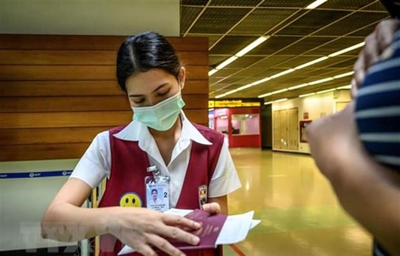 Nh&acirc;n vi&ecirc;n kiểm tra hộ chiếu của một h&agrave;nh kh&aacute;ch tại s&acirc;n bay Don Mueang ở Bangkok, Th&aacute;i Lan, ng&agrave;y 21/1/2020. (Ảnh: AFP/TTXVN)