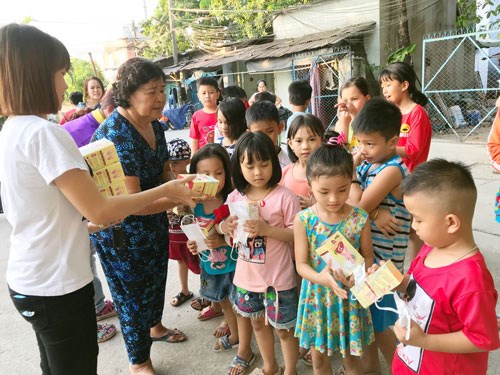 B&agrave; Nguyễn Thị Th&agrave;nh ph&aacute;t khẩu trang cho con c&ocirc;ng nh&acirc;n tại khu nh&agrave; trọ - Ảnh: b&aacute;o Người Lao Động