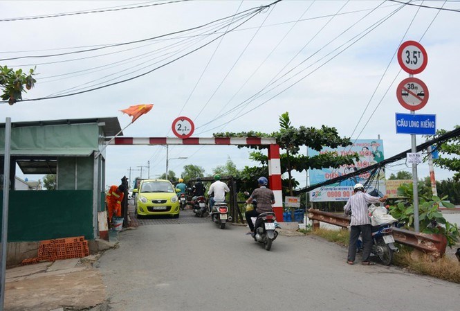 Cầu Long Kiểng mới chưa xong n&ecirc;n người d&acirc;n h&agrave;ng ng&agrave;y phải lưu th&ocirc;ng qua c&acirc;y cầu cũ bằng sắt từng bị sập một lần do xe qu&aacute; tải.