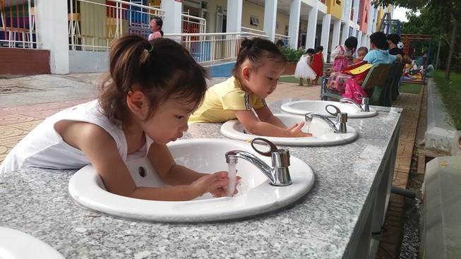 Trẻ rửa tay tại bồn rửa tay d&atilde; chiến ở Trường mầm non Hoa Hồng, quận Thủ Đức. Ảnh: PHẠM ANH