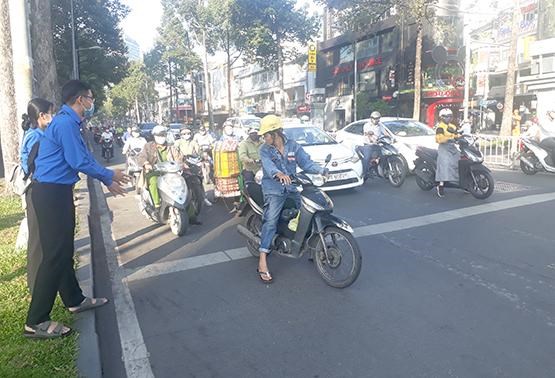 Đo&agrave;n vi&ecirc;n, thanh ni&ecirc;n Quận đo&agrave;n Q.1 đang nhắc nhở người tham gia giao th&ocirc;ng n&ecirc;n dừng xe đ&uacute;ng vạch. Ảnh: B&aacute;o Gi&aacute;o Dục