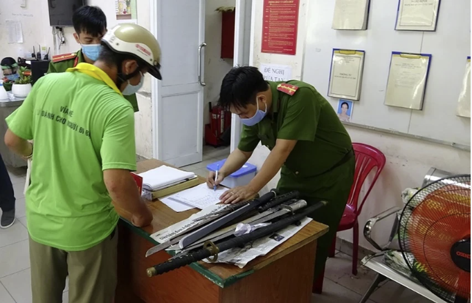 Người d&acirc;n giao nộp vũ kh&iacute; tại quận 1 được tặng 10kg gạo. Ảnh: CA