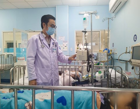 TS-BS Nguyễn Minh Tuấn đang kiểm tra cho một bệnh nhi mắc sốt xuất huyết tại Bệnh viện Nhi Đồng 1 - TP HCM. (Ảnh: ANH THƯ)