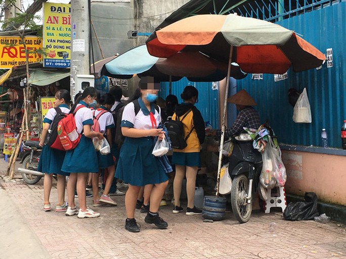 Học sinh tan trường v&acirc;y quanh xe h&agrave;ng rong mua thức ăn trước cổng Trường THCS Đồng Đen (huyện B&igrave;nh Ch&aacute;nh, TP HCM) Ảnh: THU HỒNG