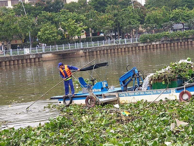 C&ocirc;ng nh&acirc;n dọn r&aacute;c tr&ecirc;n k&ecirc;nh Nhi&ecirc;u Lộc Thị Ngh&egrave;/ Ảnh: Nguyễn Ch&acirc;u (b&aacute;o Ph&aacute;p Luật TP.HCM)